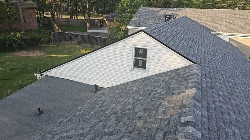 Aerial view of a new asphalt shingle roof section on a home