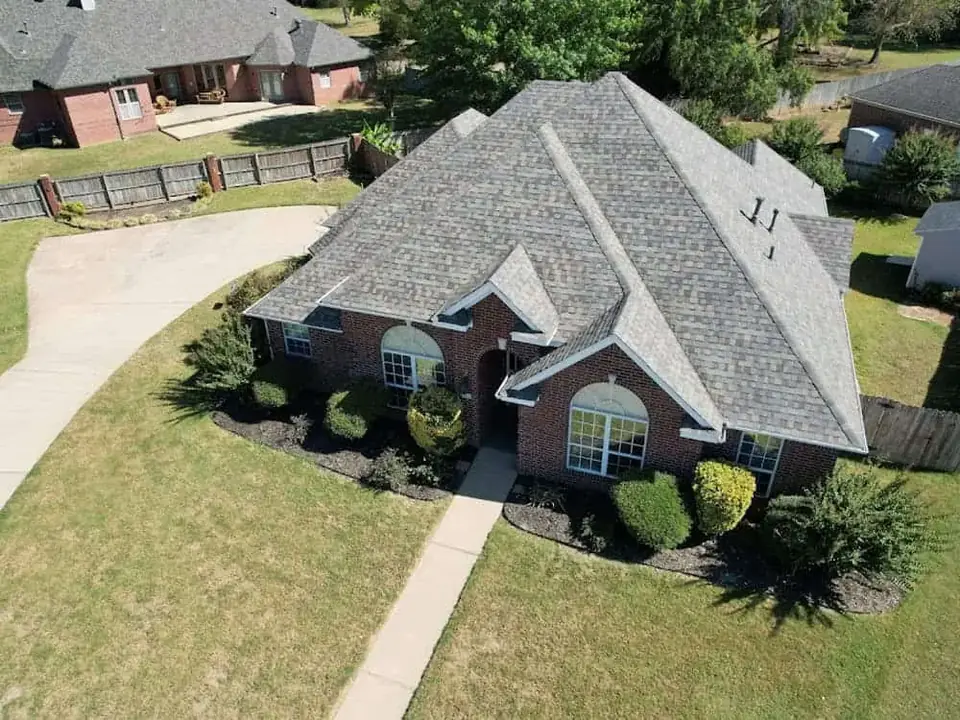 Drone view of a brick home with a new gray architectural shingle roof