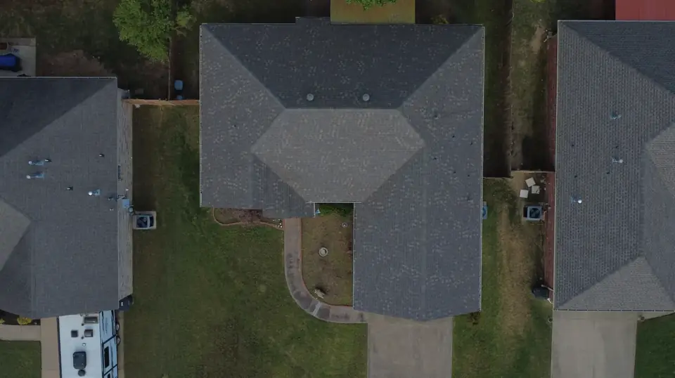 Close view of a new shingle roof around two white dormers