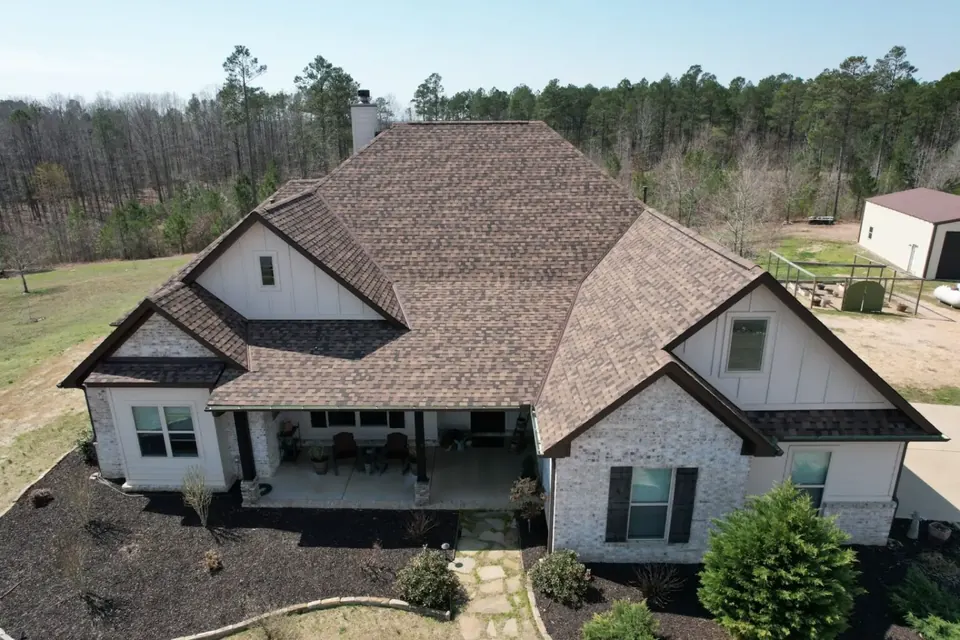 Drone view of a new brown architectural shingle roof on a farmhouse-style home