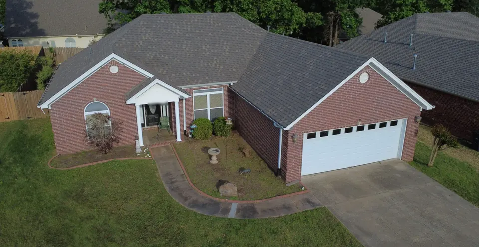 Drone view of a single-story brick home after a full roof replacement