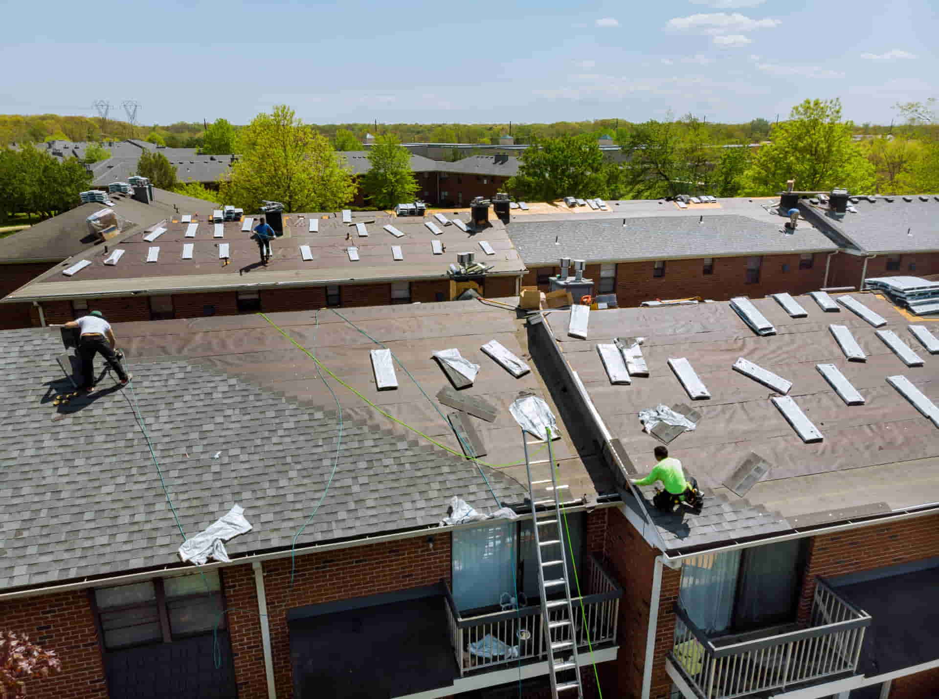 Roofing crew replacing a large residential roof