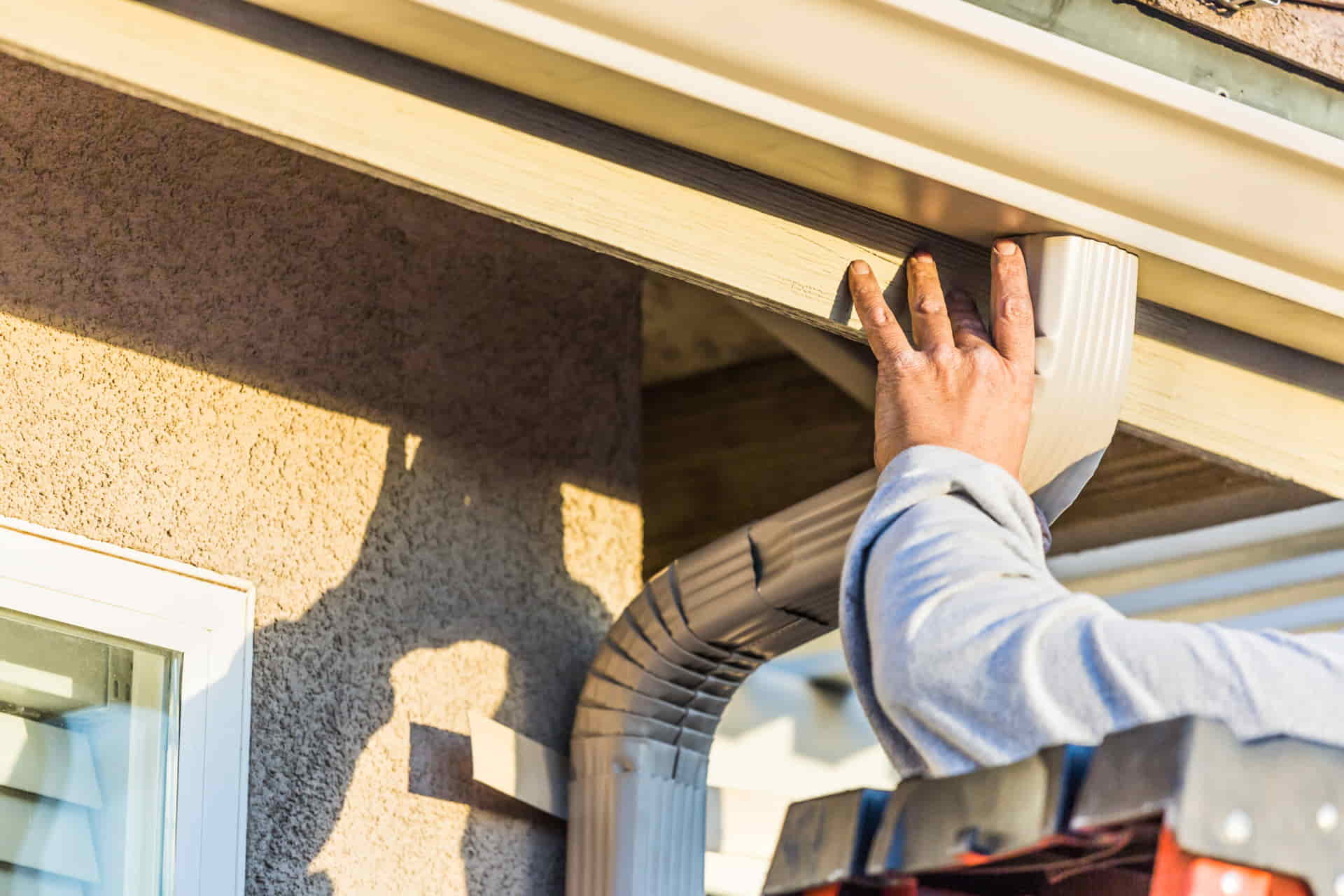 Installer fitting a gutter downspout