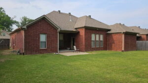 Red brick house with a covered patio area