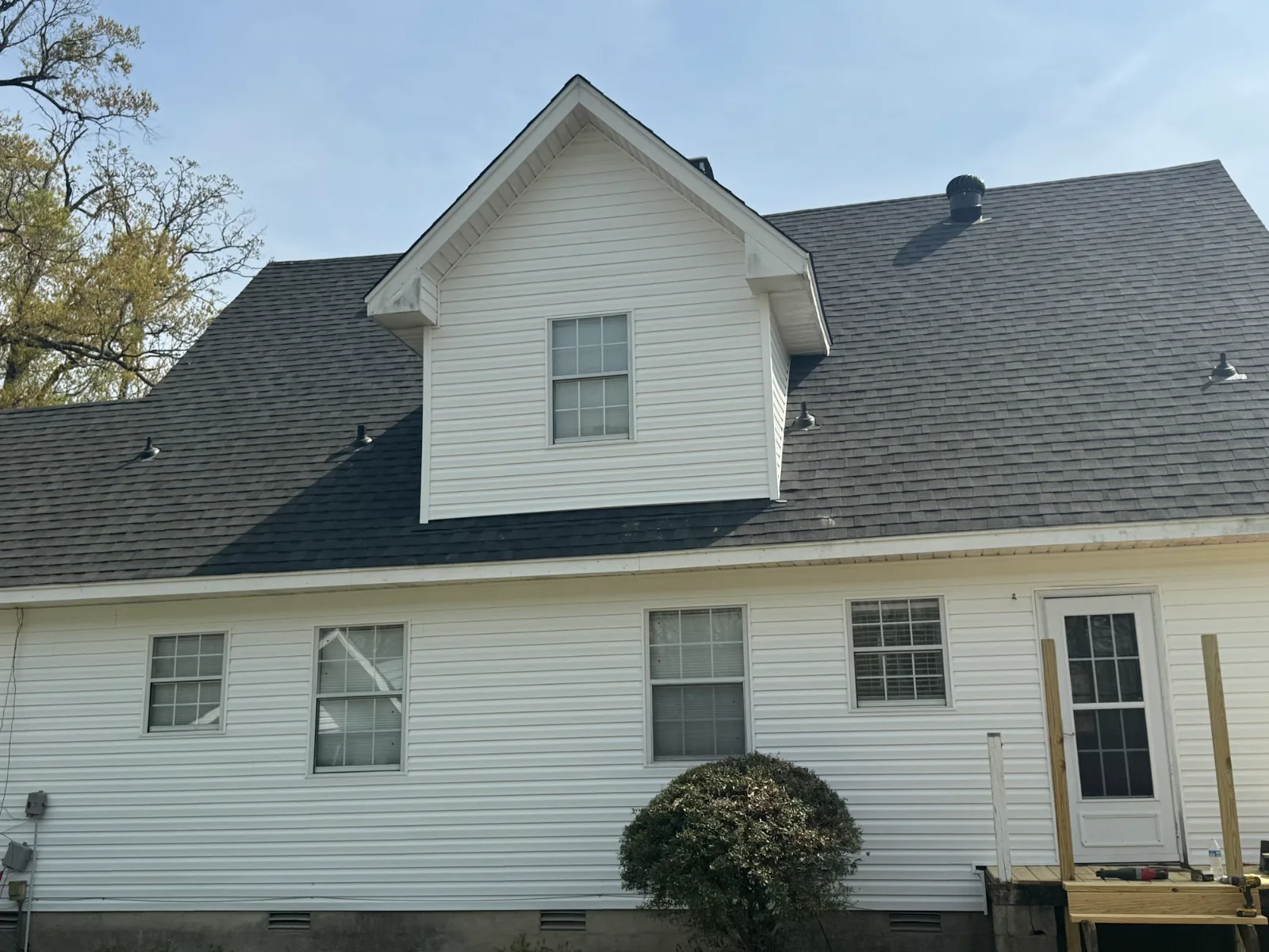 White home with a dark shingle roof and dormer