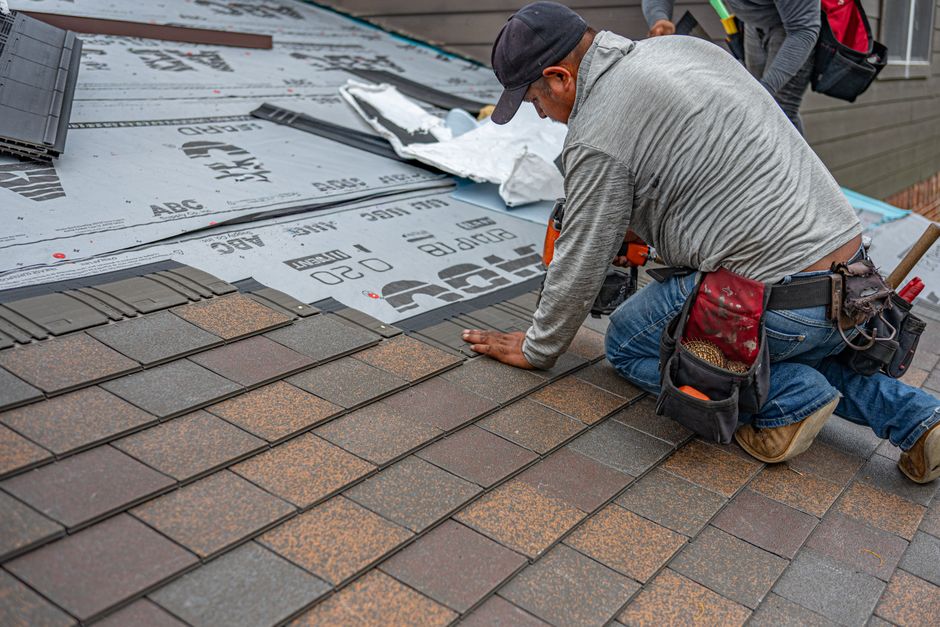 roofing contractor inspecting shingles on a house in Little Rock AR