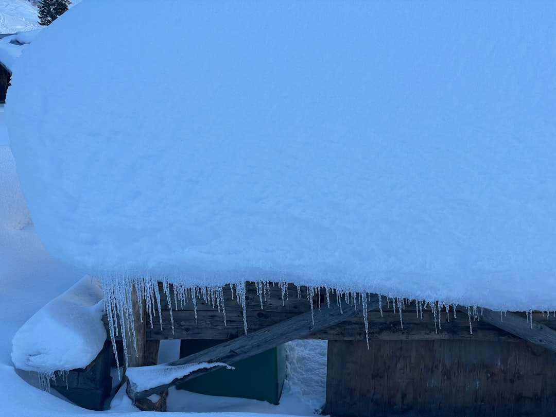ice dam on roof edge with trapped water backing up under shingles