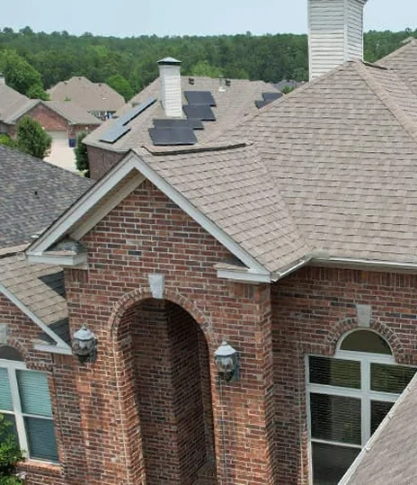 Brick home with an arched entry and a shingle roof
