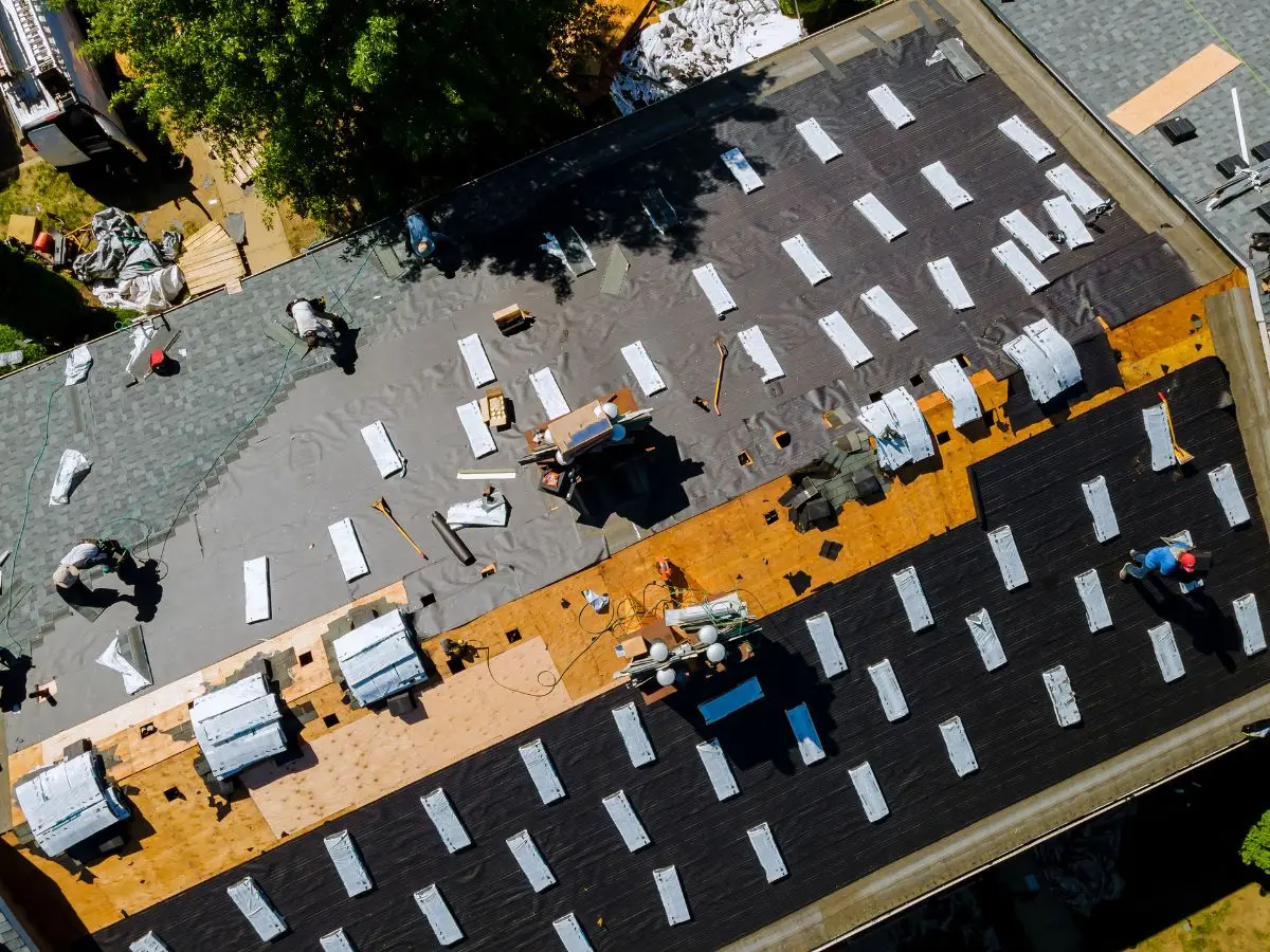 Roofers installing architectural shingles on roof deck