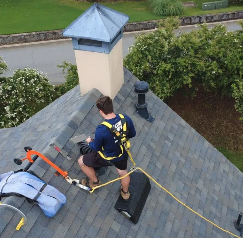 Roofer carrying materials up to a roof