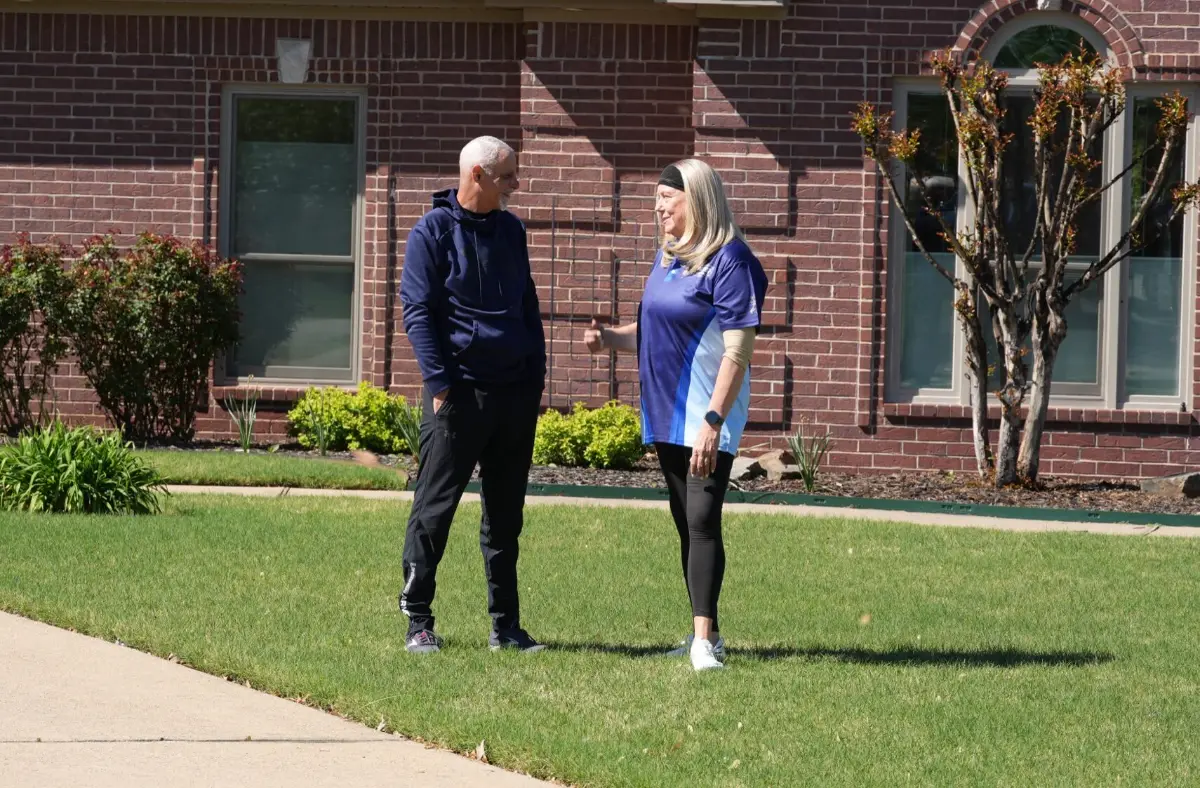 Patriot Roofing representative talking with a homeowner outside their house